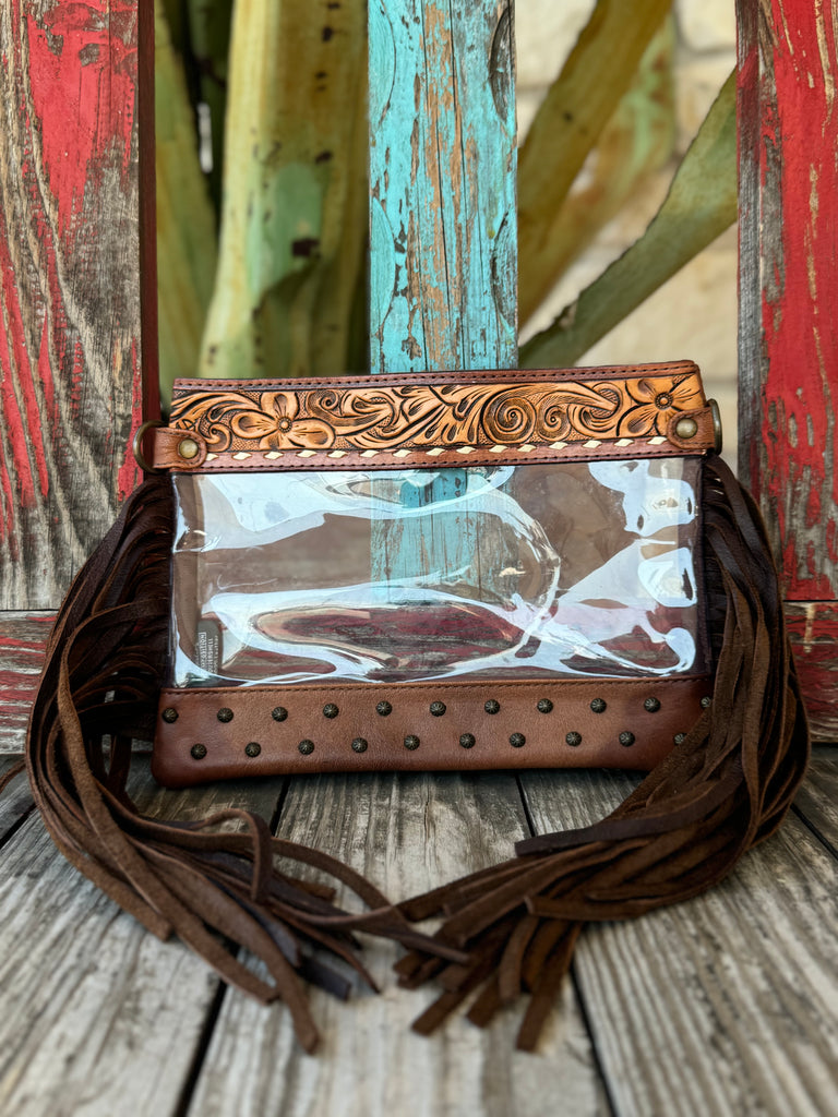Women’s American Darling clear crossbody purse in brown leather, with hand-tooled floral trim, clear vinyl body, and side fringe for Western flair – ADBG1174A. Available at Blair’s Western Wear, Marble Falls, TX.