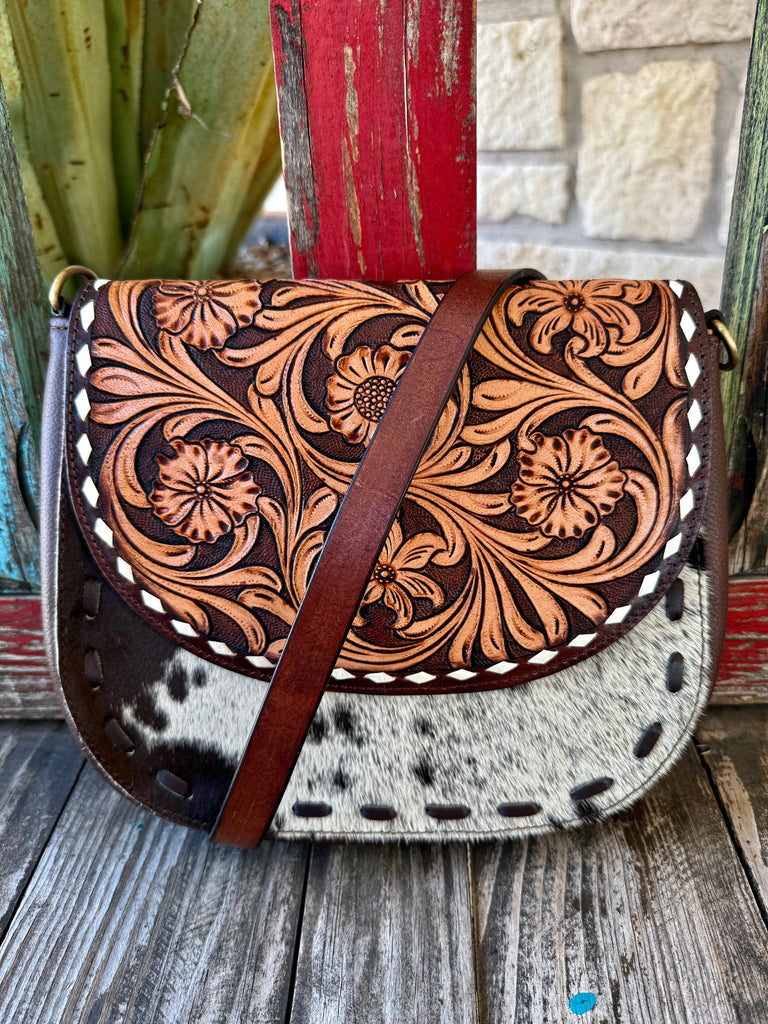 Women’s American Darling crossbody tool flap hide purse in brown, natural, and tan, featuring hand-tooled floral leather flap with genuine hair-on cowhide body and adjustable leather crossbody strap - ADBGA211G. Available at Blair's Western Wear, Marble Falls, TX.