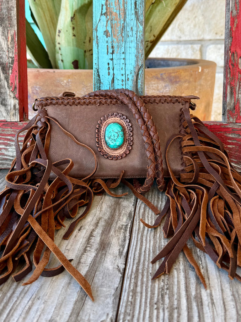 Women’s American Darling Crossbody Fringe Stone Bag in Brown, genuine full-grain leather that develops rich patina over time, with statement turquoise stone centerpiece and long leather fringe detailing - ADBGM277B. Available at Blair's Western Wear, Marble Falls, TX.