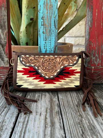 Women’s American Darling crossbody bag in brown leather and red serape weave, featuring hand-tooled floral flap and fringe sides, with zippered back pocket and detachable strap – ADBGA188Q. Available at Blair's Western Wear, Marble Falls, TX.