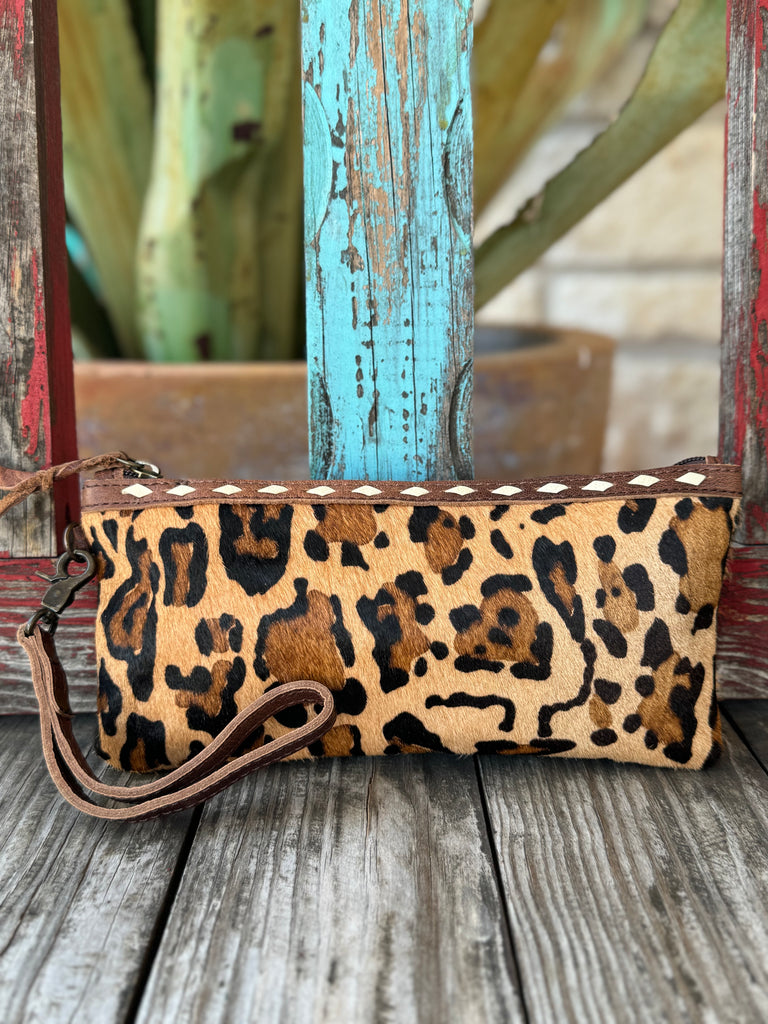 Women’s American Darling hair-on hide leopard wristlet in tan and black, featuring full-grain leather trim and detachable wrist strap – ADBG344AF. Available at Blair’s Western Wear, Marble Falls, TX.