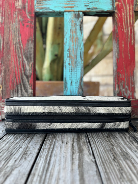 Women’s American Darling jewelry case in black and white hair-on hide, with dual zipper closure and soft suede interior featuring mesh pocket and elastic loops – ADBGA707A. Available at Blair's Western Wear, Marble Falls, TX.