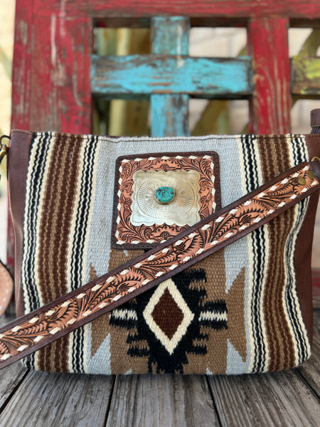 Women’s American Darling saddle blanket leather messenger bag in brown with hand-tooled strap, turquoise concho detail, and concealed carry pocket – ADBGA286A. Available at Blair’s Western Wear, Marble Falls, TX.