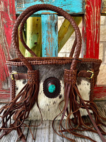 Women’s American Darling tote fringe shoulder bag in natural hide, hair-on hide body with hand-braided leather trim, featuring turquoise concho detail and genuine leather fringe - ADBGM259D. Available at Blair's Western Wear, Marble Falls, TX.