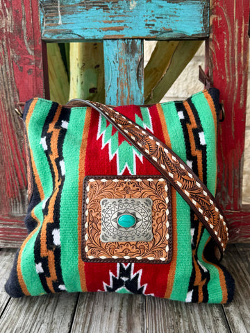 Women’s American Darling Tote Aztec Tote in turquoise, handwoven Aztec blanket front for bold Western style, with tooled leather strap and turquoise concho detail - ADBGA268C. Available at Blair's Western Wear, Marble Falls, TX.