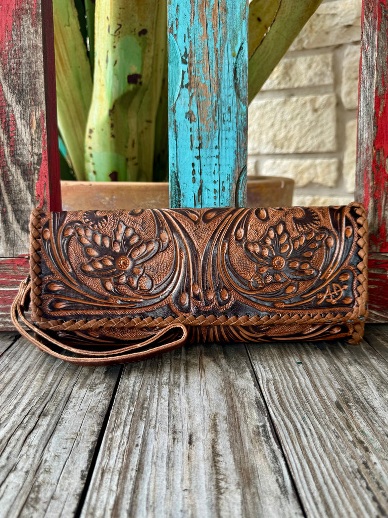 Women’s American Darling wristlet clutch in brown, hand-tooled floral leather design, with braided leather edging and a secure snap-button closure – ADBG1106. Available at Blair's Western Wear, Marble Falls, TX.