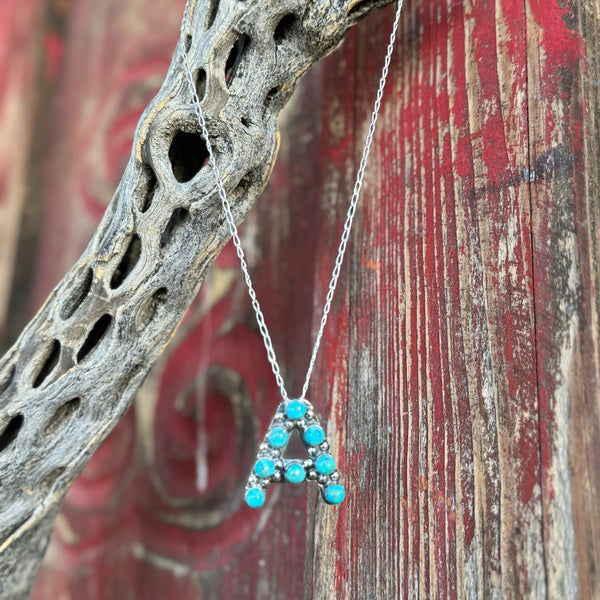 Women's Boho Sol Necklace Bubble Letter Pendant in Turquoise, handcrafted with vibrant turquoise cabochons, with a durable sterling silver base - T320. Available at Blair's Western Wear, Marble Falls, TX.