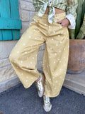 IP200313-09 — Women's butterscotch golden yellow wide leg barrel pants with large scattered white polka dots, rounded voluminous barrel silhouette, structured denim-weight fabric with contrast topstitching, curved front seam detail, mid/high-rise flat waistband with belt loops, and angled slash pockets — Blair's Western Wear Marble Falls TX