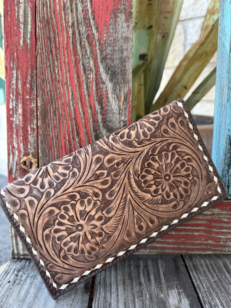 ADBGZ584B — Women's rich dark chocolate brown full-grain leather long bifold wallet with deep full-coverage floral and scroll hand-tooling, two large daisy/sunflower motifs with sweeping acanthus leaf scrollwork, cream/ivory whipstitch lace trim all around, and snap closure at the top — Blair's Western Wear Marble Falls TX