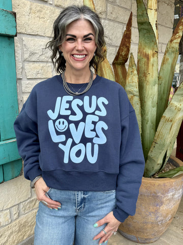 Women’s blue graphic sweatshirt pullover with “Jesus Loves You” design, relaxed fit with soft fleece interior - make famous. Available at Blair's Western Wear, Marble Falls, TX
