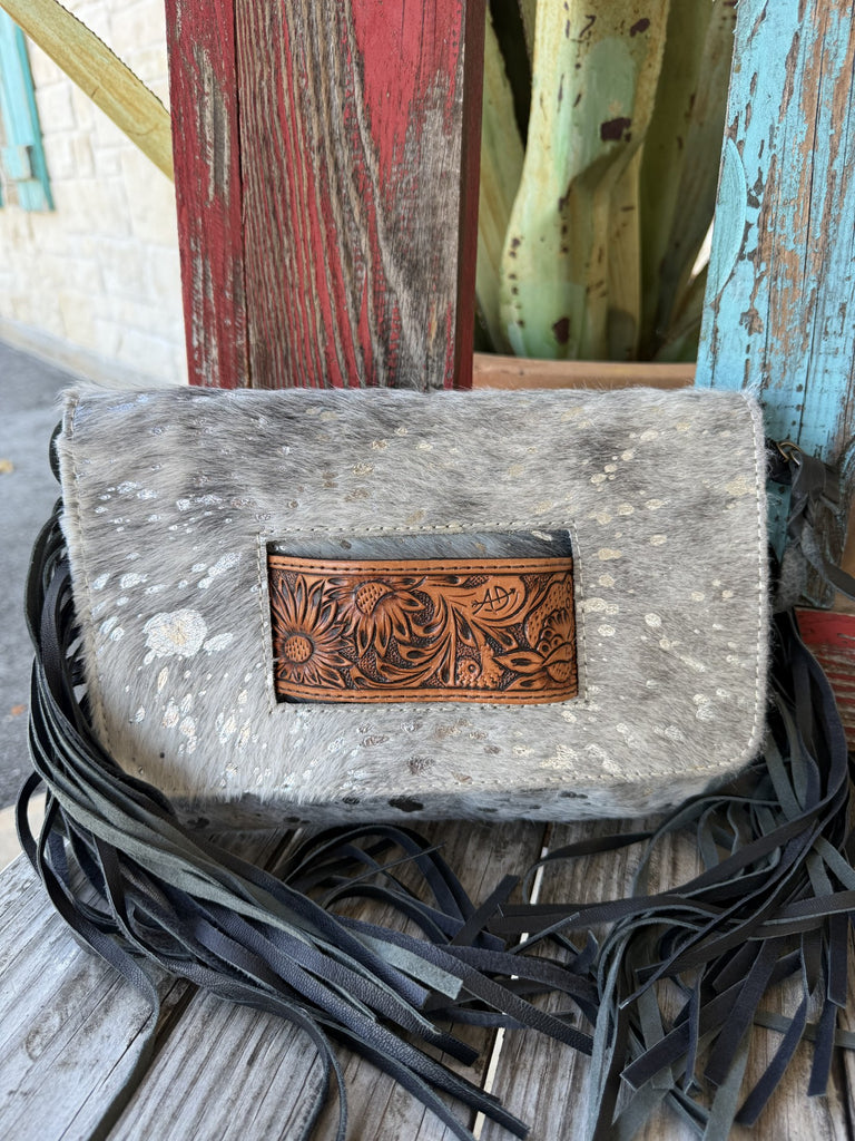 ADBG360ACSL — Women's grey and silver acid-wash splatter hair-on cowhide fringe crossbody clutch with rectangular pale natural tan hand-tooled sunflower and acanthus scroll leather inset centered on the front, long dark navy/black leather fringe on both sides, envelope flap closure, and detachable dark crossbody strap — Blair's Western Wear Marble Falls TX