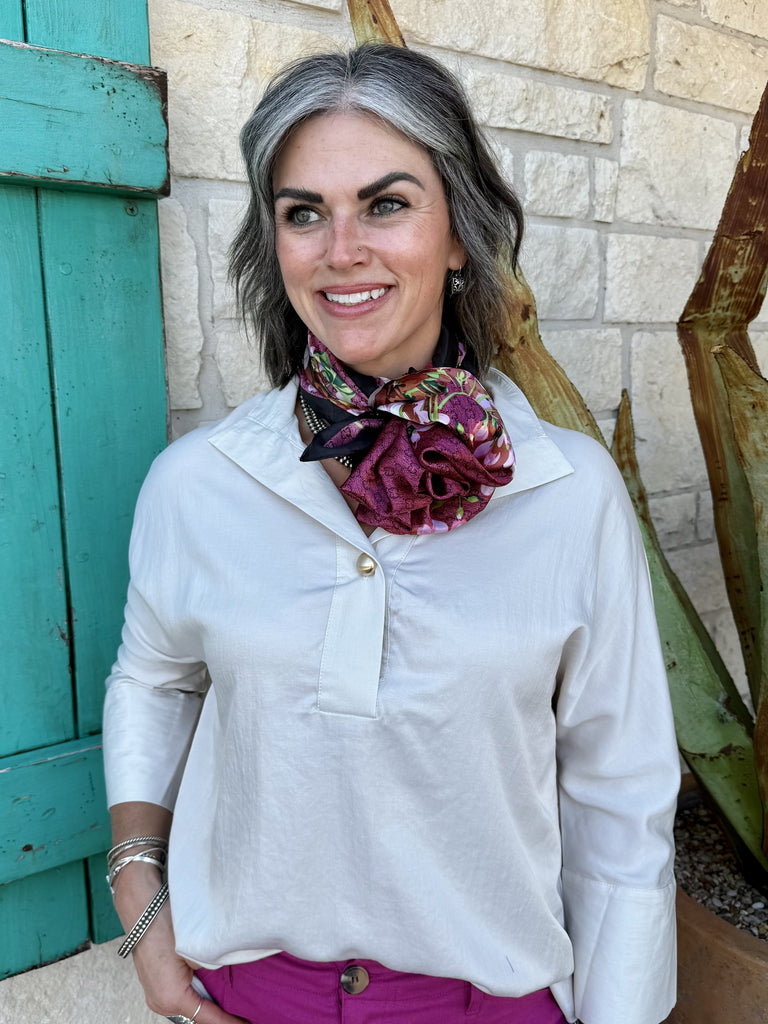 T8274I — Women's ivory cream 3/4 sleeve pullover tunic with collared button placket neckline, single concho button cuff detail, relaxed boxy fit, and tunic length, styled with magenta wide leg trousers, floral wild rag, and gold sandals — Blair's Western Wear Marble Falls TX
