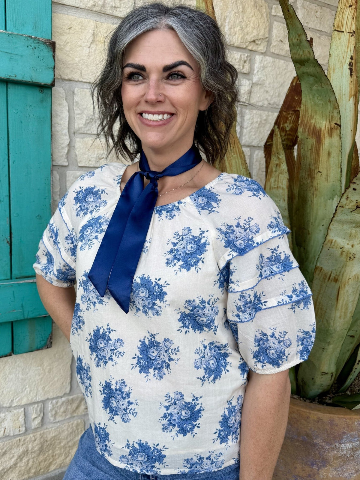 Women’s Ivy Jane blouse floral top in cream and blue, lightweight fabric with tiered puff sleeves and navy tie neckline - 641483. Available at Blair's Western Wear, Marble Falls, TX.