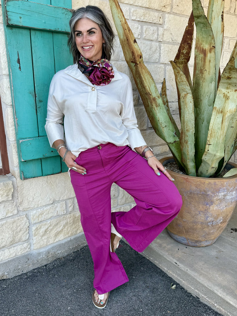 GP9562M — Women's magenta fuchsia high rise wide leg dress pant with structured waistband, generous wide leg silhouette, side seam pockets, and full floor-grazing length, styled with ivory 3/4 sleeve pullover tunic, floral wild rag, and gold sandals — Blair's Western Wear Marble Falls TX