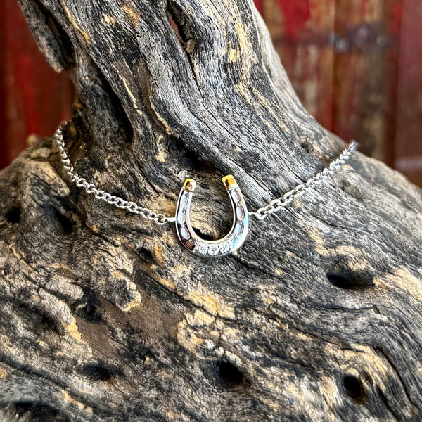 Women’s Montana Silversmiths silver horseshoe bracelet with clear stones for subtle sparkle, featuring gold-tone tip accents for contrast - QBC6429. Available at Blair's Western Wear, Marble Falls, TX.