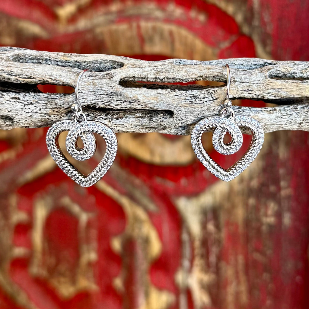 Women’s Montana Silversmiths silver heart dangle earrings in textured open-heart design, lightweight for comfortable wear, with secure French hook ear wires – ER6472. Available at Blair's Western Wear, Marble Falls, TX.