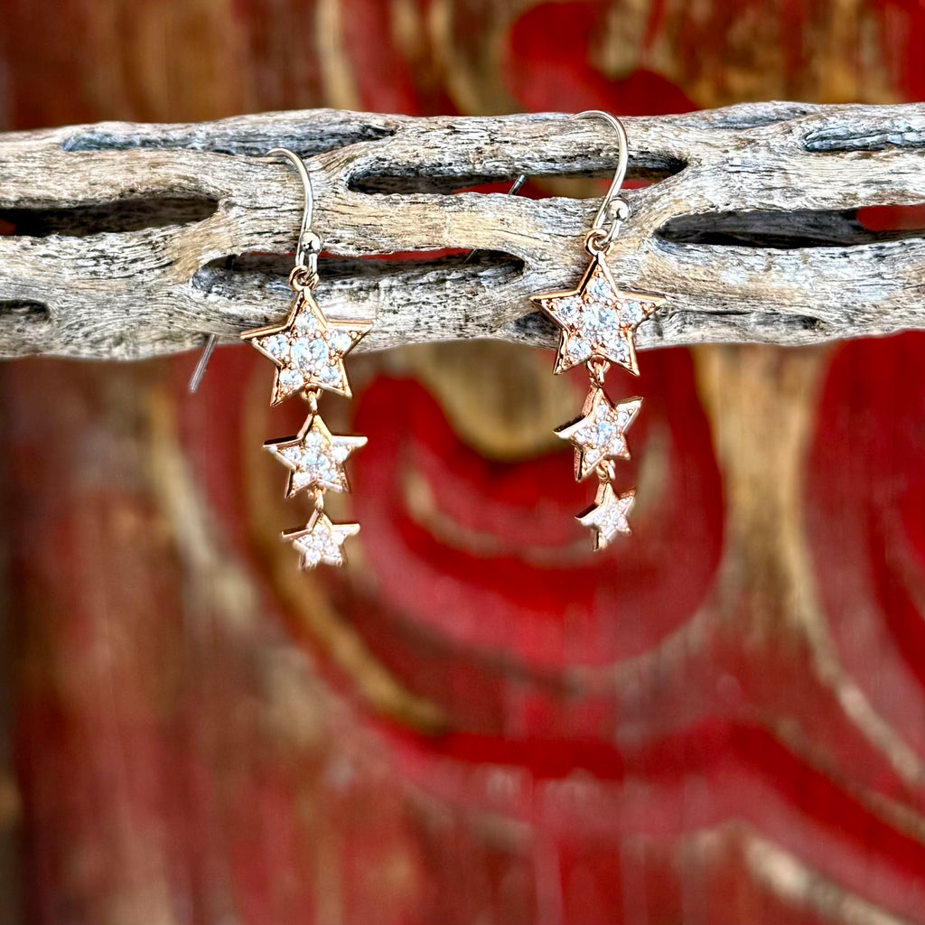 Women’s Montana Silversmiths earrings dangle star earrings in rose gold tone, cascading star design that adds movement, with clear cubic zirconia sparkle for everyday shine - ER6311. Available at Blair's Western Wear, Marble Falls, TX.