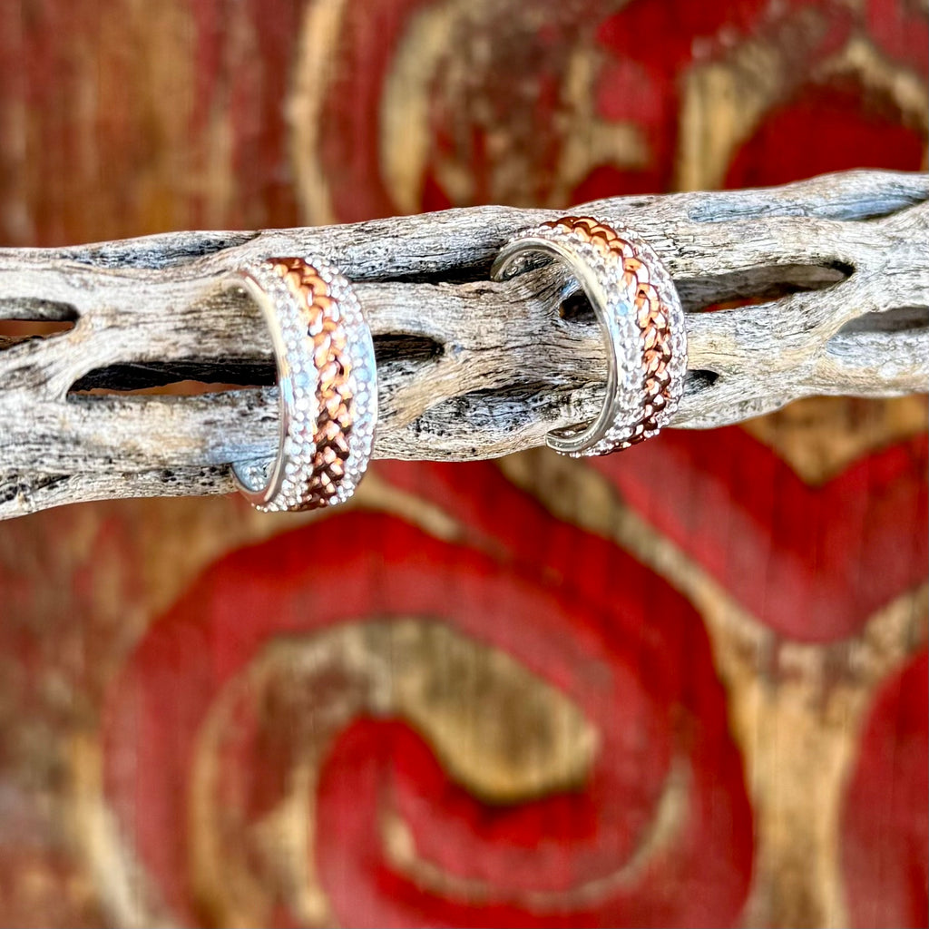 Women’s Montana Silversmiths hoop earrings in silver and copper, braided copper center detail for textured contrast, with clear crystal accents for subtle shine – ER6446. Available at Blair's Western Wear, Marble Falls, TX.
