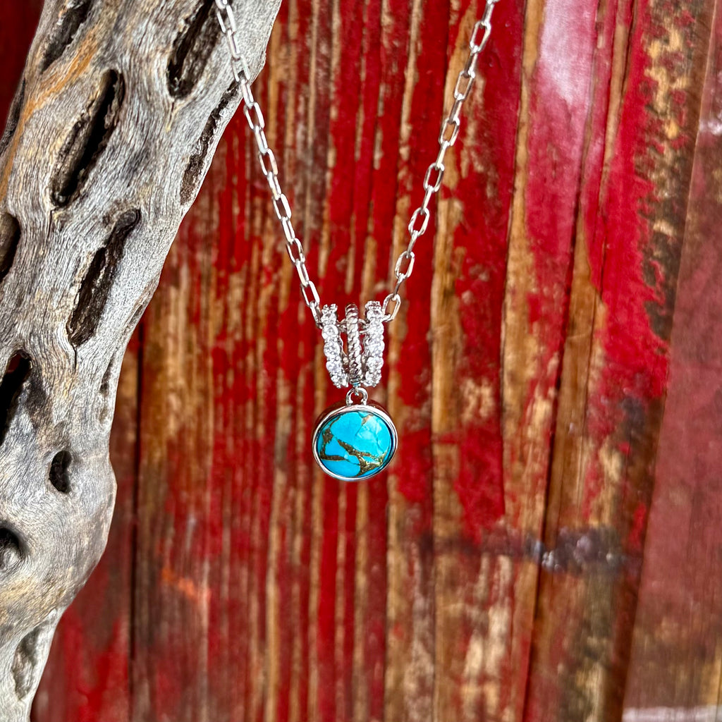 Women’s Montana Silversmiths necklace turquoise pendant in silver-tone, genuine turquoise stone centerpiece delivers bold Southwestern color with natural matrix detailing, with triple crystal-accented bail adds subtle sparkle at the neckline - NC6483. Available at Blair's Western Wear, Marble Falls, TX.
