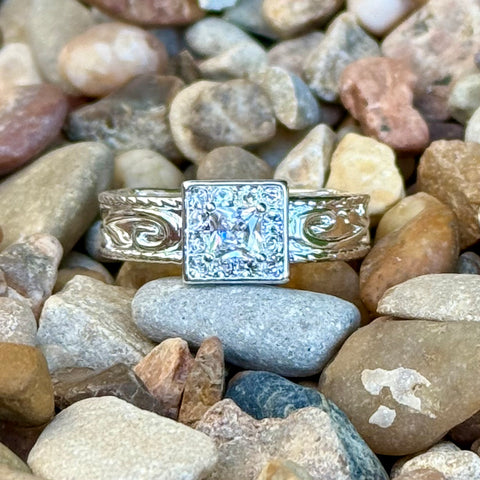 Women’s Montana Silversmiths ring in silver with square cubic zirconia halo center that reflects light from multiple angles, with engraved desert-inspired scrollwork band - RG6456. Available at Blair's Western Wear, Marble Falls, TX.
