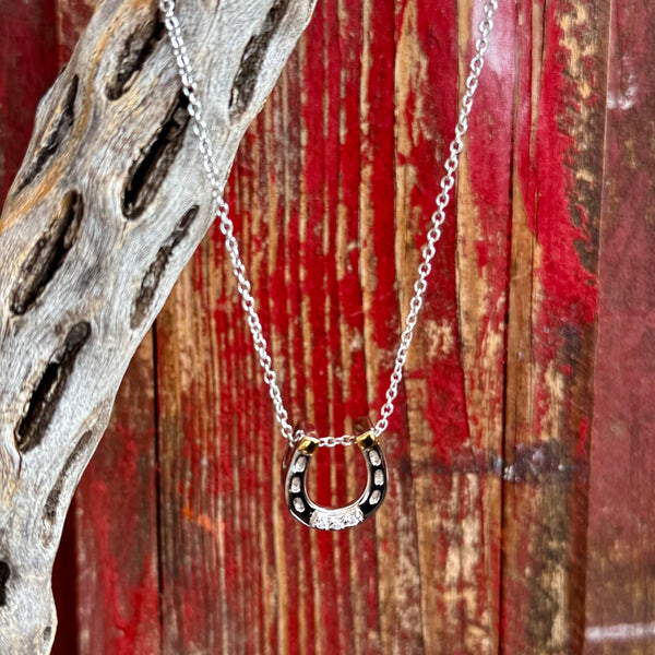 Women's Montana Silversmiths silver necklace in horseshoe pendant style, silver-tone finish with contrasting black inlay enhances depth and detail, with clear cubic zirconia stones set along the horseshoe for added sparkle - QNC6429. Available at Blair's Western Wear, Marble Falls, TX.