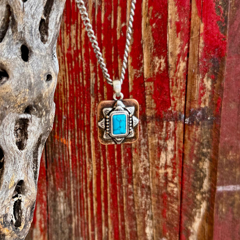 Women’s Montana Silversmiths silver and turquoise Sienna Canyon necklace in turquoise, rectangular turquoise stone centerpiece that adds vibrant color and eye-catching contrast, with layered silver-tone frame and warm copper-tone background for a bold Western look - NC6480. Available at Blair's Western Wear, Marble Falls, TX.