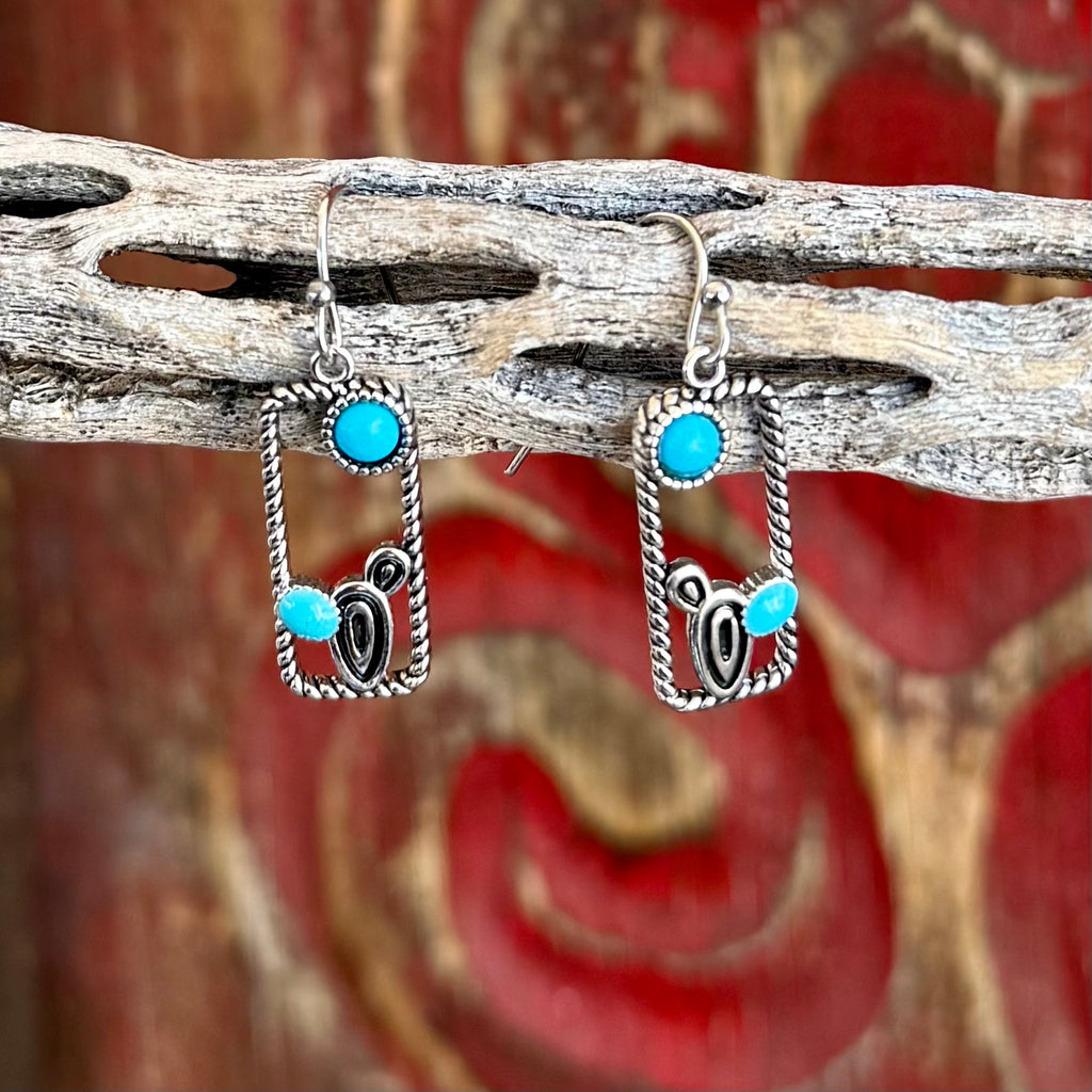 Women’s Montana Silversmiths turquoise rectangle earrings in silver tone, with tarnish-resistant twisted rope frame, accented by turquoise stones and silver scroll detail – ER6327. Available at Blair’s Western Wear, Marble Falls, TX.