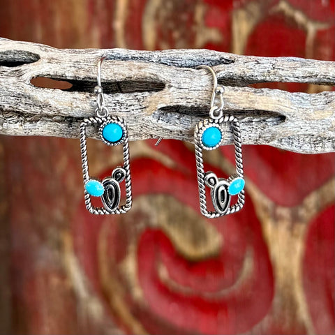 Women’s Montana Silversmiths turquoise rectangle earrings in silver tone, with tarnish-resistant twisted rope frame, accented by turquoise stones and silver scroll detail – ER6327. Available at Blair’s Western Wear, Marble Falls, TX.