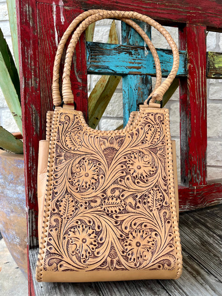 ADBGZ767A — Women's pale natural tan vegetable-tanned cowhide structured tote with deep full-coverage floral and acanthus leaf scroll hand-tooling with dark brown/mahogany antiqued contrast, two braided/plaited round leather top handles, and whipstitch lace trim along all outer edges — Blair's Western Wear Marble Falls TX