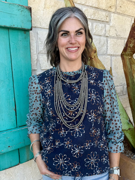 37183V — Full-length view of women's navy floral embroidered mixed media long sleeve top showing navy embroidered knit body, sheer sage dot-print chiffon sleeves with gathered cuffs, and relaxed fit — Blair's Western Wear Marble Falls TX