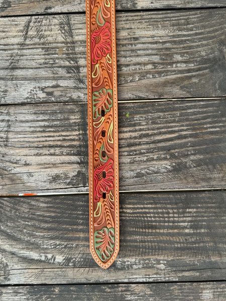 Natural tan tooled leather with hand-painted coral flowers and sage green leaves — a beautifully crafted western belt with cream stitched edges. Available at Blair's Western Wear located in Marble Falls, TX.