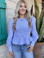 Women’s periwinkle stripe smocked blouse top in blue and white, featuring a flattering smocked bodice with a flowy peplum hem - IT10060. Available at Blair's Western Wear, Marble Falls, TX.