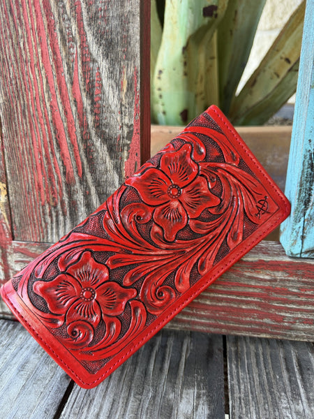 Women's red hand-tooled leather zip wallet with deep floral and scroll carving and dark antiqued finish, angled front view — Blair's Western Wear Marble Falls TX