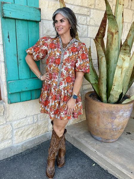 72670 — Women's retro floral puff sleeve tiered mini dress with bold red, pink, burnt orange, and golden floral print on caramel base, leopard contrast trim along spread collar and center front placket, short puff sleeves, and drop-waist tiered ruffle skirt — Blair's Western Wear Marble Falls TX