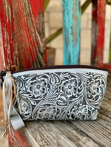ADBG1234J — Women's slim silver and dark charcoal two-tone full-coverage floral and scroll embossed leather wristlet with large pansy and poppy blooms and sweeping acanthus leaf carving across the entire surface, dark chocolate/espresso brown leather zipper trim along the top, removable silver leather fringe tassel wristlet strap hanging from the left side zipper pull, and compact 11x6 inch trapezoid silhouette — Blair's Western Wear Marble Falls TX