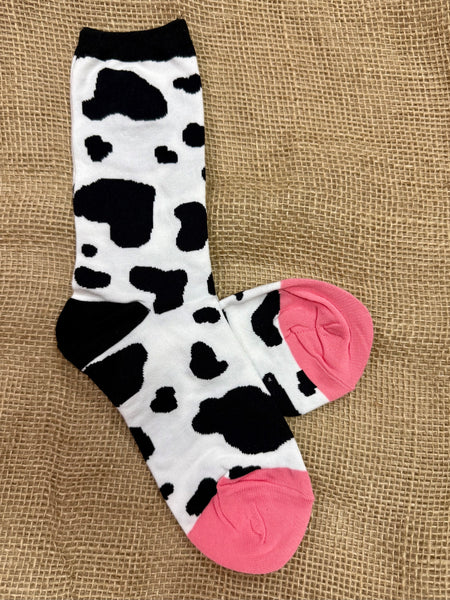 Women’s Socksmith cow print crew socks in white with black spots and pink toes, featuring breathable cotton blend, with reinforced heel and toe for lasting comfort - WNC1886. Available at Blair's Western Wear, Marble Falls, TX.