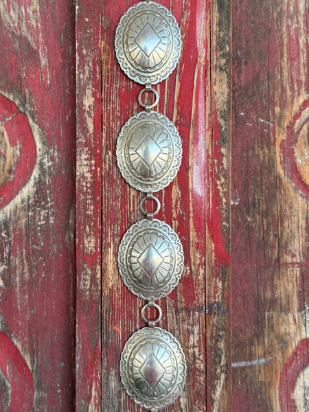 Make a lasting impression with this stunning Sunwest concho belt. Oval-linked conchos showcase intricate stamped Southwestern-inspired patterns, delivering that authentic Western artistry you can feel as much as see — beautifully crafted and endlessly wearable.