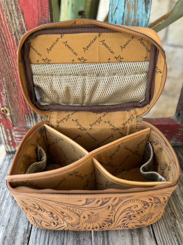 ADBG1251G — This gorgeous tan leather train case is covered in full-coverage deep hand-carved sunflower and feather scroll tooling with dark brown antiqued contrast, a smooth tan leather top lid, zip-around tan zipper, and reinforced tan leather carry handle with dark hardware — pure western artisan style — Blair's Western Wear Marble Falls TX