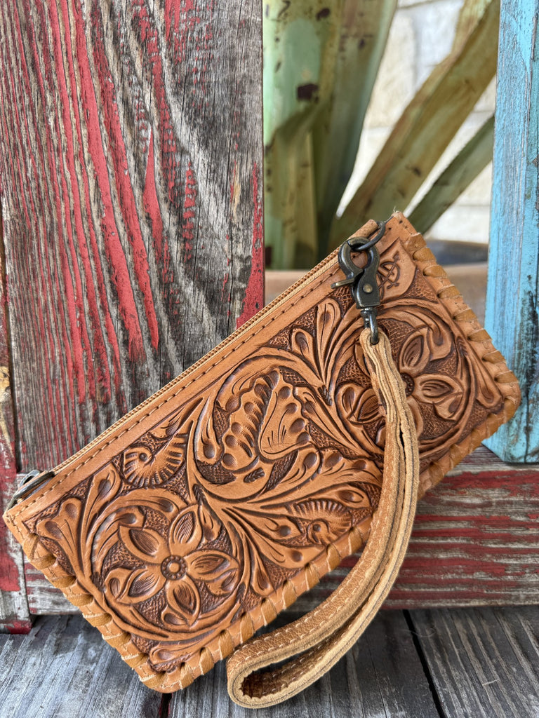 ADBG535TAN — Women's slim tan full-coverage floral and acanthus scroll hand-tooled leather clutch with two circular daisy/sunflower medallion carvings flanking a central poppy blossom, cream leather lace whipstitch on all four edges, antique brass zipper closure, and antique brass zipper pull on the right side — Blair's Western Wear Marble Falls TX