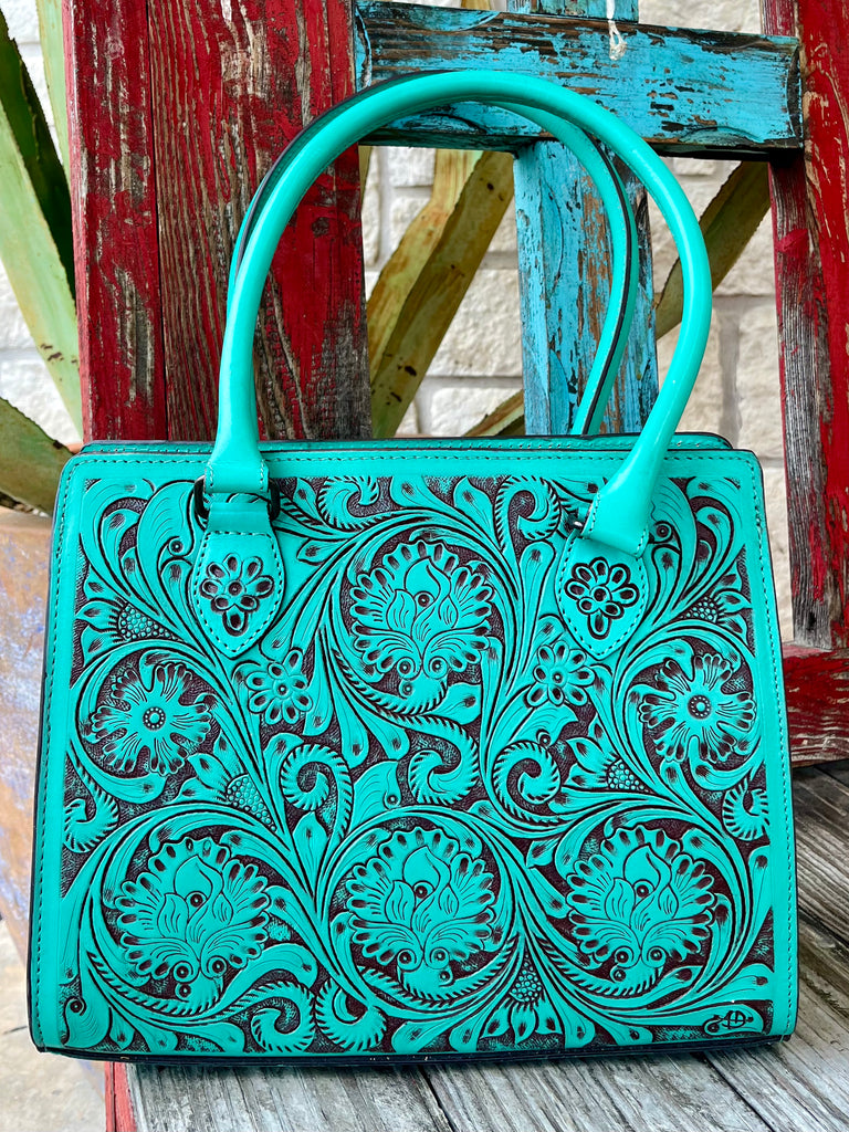 ADBGZ732B — Women's structured turquoise and dark brown full-coverage floral and scroll hand-tooled leather satchel with vibrant turquoise dye on raised carved surfaces over dark chocolate/espresso brown leather base, multiple large circular floral medallions with sweeping acanthus scroll and leaf carving across entire front panel, smooth matching turquoise leather top handles, top-center zip closure with leather pull tab, dark chocolate leather base trim, and American Darling AD brand stamp on lower right 