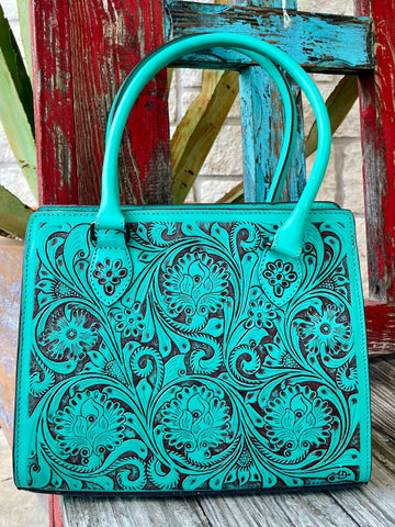 ADBGZ732B — Women's structured turquoise and dark brown full-coverage floral and scroll hand-tooled leather satchel with vibrant turquoise dye on raised carved surfaces over dark chocolate/espresso brown leather base, multiple large circular floral medallions with sweeping acanthus scroll and leaf carving across entire front panel, smooth matching turquoise leather top handles, top-center zip closure with leather pull tab, dark chocolate leather base trim, and American Darling AD brand stamp on lower right 