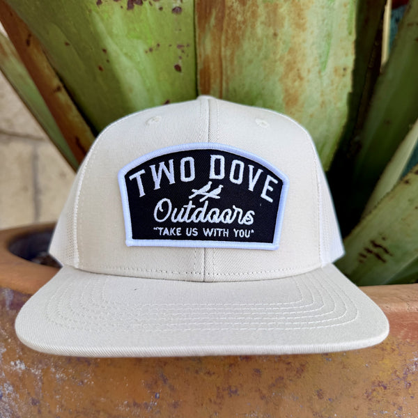 Tan structured snapback cap with black and white Two Dove Outdoors woven patch and dove silhouette on front panel, flat brim — Blair's Western Wear Marble Falls TX