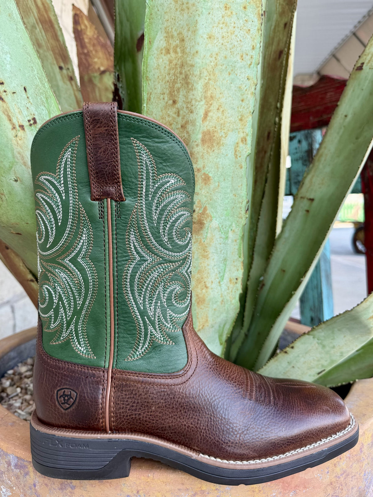 Men's Western boot with a textured brown leather foot, green embroidered shaft, brown pull tab, square toe, and black cushioned sole — Blair's Western Wear Marble Falls TX