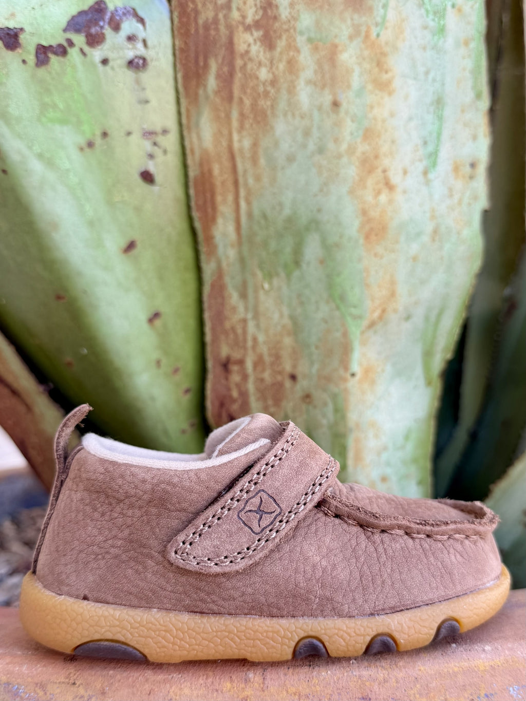 Side view of brown infant moccasin with stitched fastening strap, light lining, rear pull tab and contrasting tan sole — Blair's Western Wear Marble Falls TX