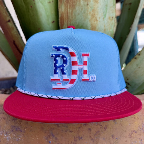 Men's red and light blue mesh trucker cap with embroidered Red Dirt Hat Co. logo in American flag red, white, and blue pattern — Blair's Western Wear Marble Falls TX