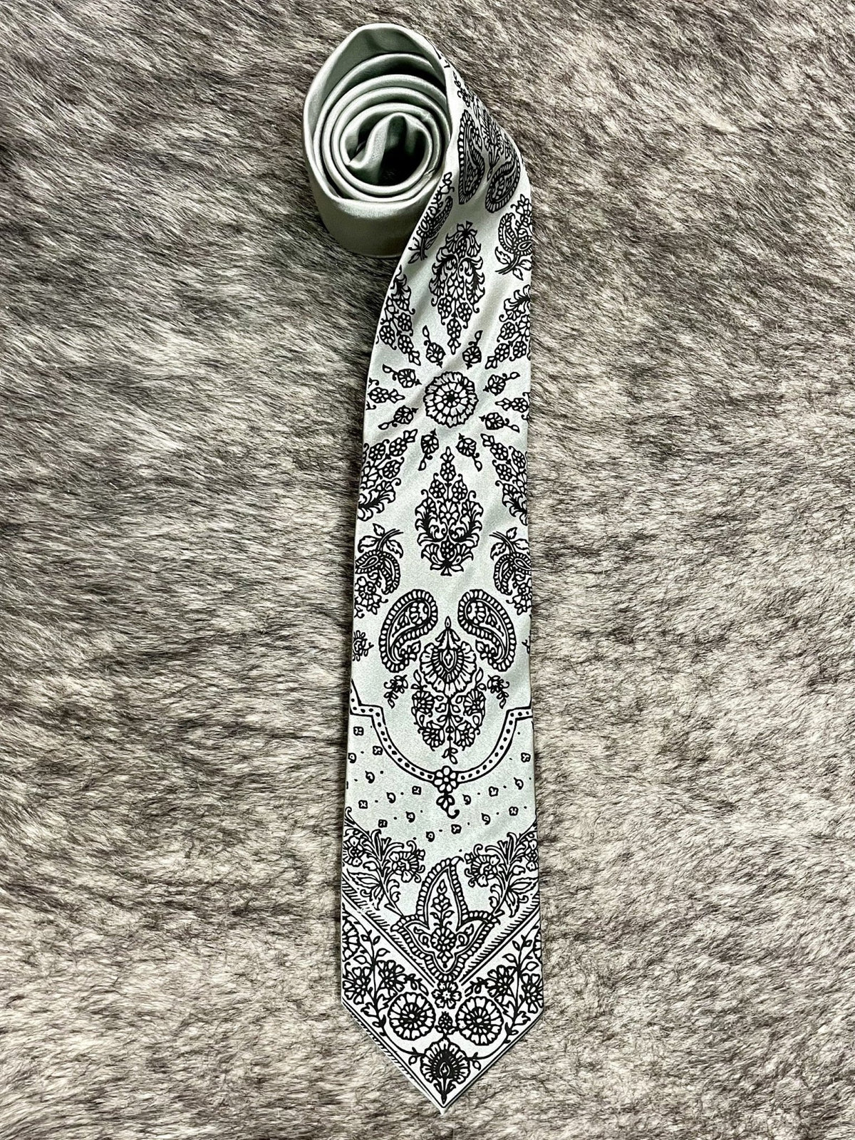 Men's light gray necktie with black bandana-inspired paisley and floral print, smooth woven finish, standard width pointed tip — Blair's Western Wear Marble Falls TX