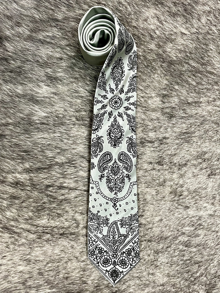 Men's light gray necktie with black bandana-inspired paisley and floral print, smooth woven finish, standard width pointed tip — Blair's Western Wear Marble Falls TX