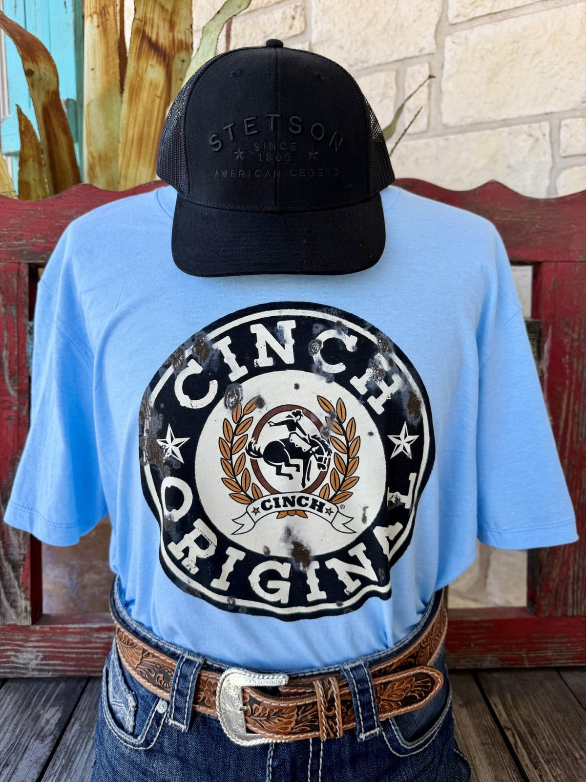 Men's light blue Cinch Original distressed bronc rider badge logo short sleeve tee, front view styled with jeans and tooled leather belt — Blair's Western Wear Marble Falls TX