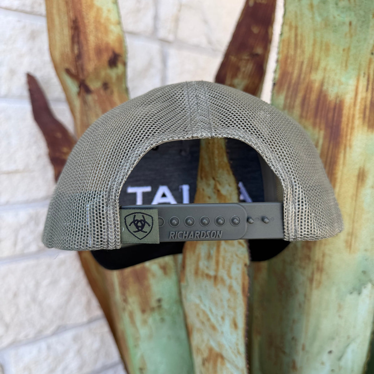 Back view of a cap in olive green mesh and black fabric, featuring an olive adjustable strap