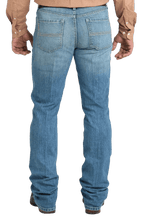 Men's slim fit stretch denim jean in medium stonewash with sanding and whisker details and boot-friendly leg opening — Blair's Western Wear Marble Falls TX